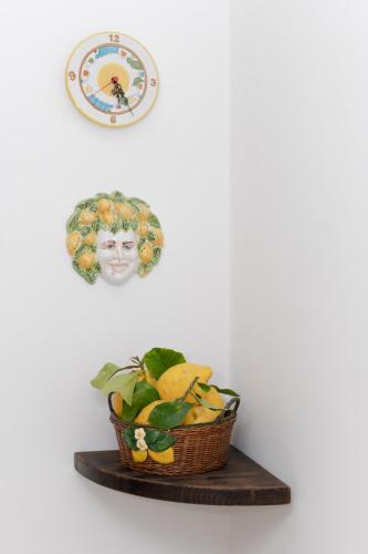 a basket of fruit on a shelf with a picture of a woman at Il Riccio Apartment 28 in Procida
