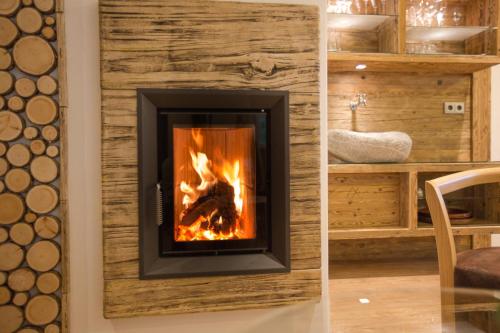 a fireplace in a wall with a fire in it at Hotel Garni Grünmoos in Sankt Jakob in Defereggen