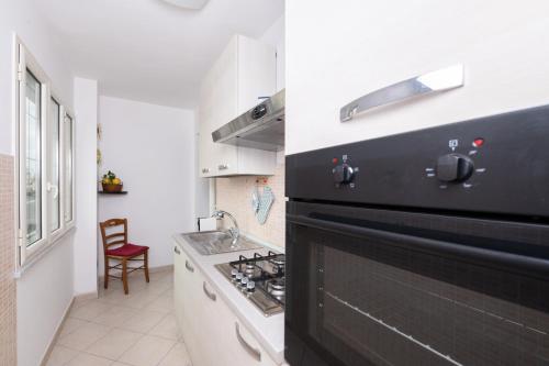 a kitchen with a black and white stove top oven at Il Riccio Apartment 28 in Procida