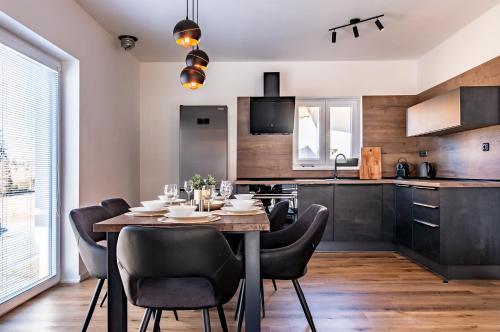 a dining room with a table and chairs in a kitchen at Lipno - Lakeside Village - Větrník in Frymburk