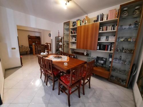 a dining room with a wooden table and chairs at la casa che vorresti in Fonte Nuova