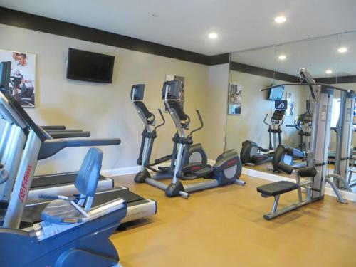 a gym with several tread machines and a mirror at The Point Hotel & Suites Universal in Orlando