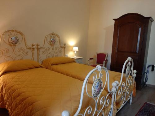 a bedroom with two beds and a wooden headboard at Bed & Breakfast La Casa Antica in Macomer