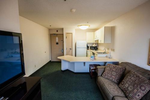 a living room with a couch and a kitchen at Greystone Inn & Suites in Vance