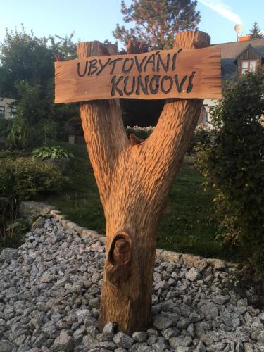 a wooden sign on top of a tree stump at Ubytování Kuncovi in Bedřichov