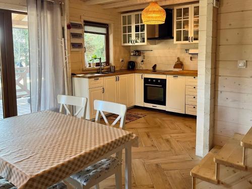 a kitchen with a table and chairs in a cabin at KrzyweProgi - domek na Mazurach nad jeziorem Krzywe in Langendorf