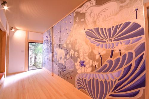 a hallway with a mural of flowers on the wall at Koyasan Shukubo Saizenin in Koyasan