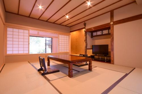 ein Wohnzimmer mit einem Tisch und einem TV in der Unterkunft 高野山 宿坊 西禅院 -Koyasan Shukubo Saizenin- in Koyasan