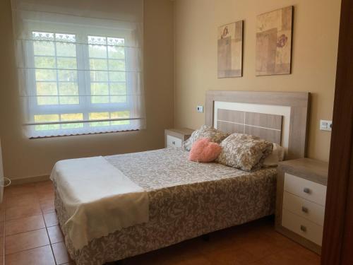 een slaapkamer met een bed met twee kussens erop bij Finis Viae in Fisterra