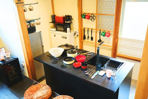 a kitchen with a counter top with bowls and utensils at オーシャンビュー 加美屋リゾート 江ノ島,江ノ島の島内,仲見世通りから3分,海と日の出を臨む貸切の和モダン別荘 in Fujisawa
