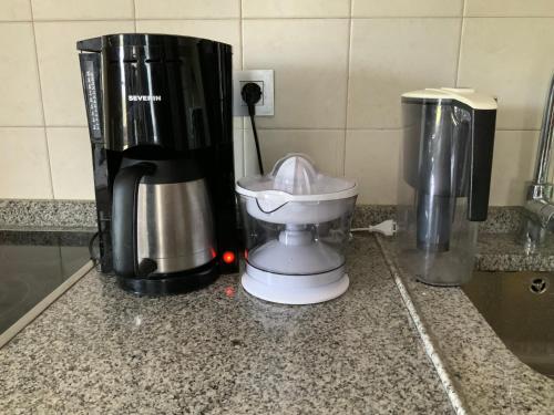 een koffiezetapparaat naast twee vuilnisbakken bij Finis Viae in Fisterra