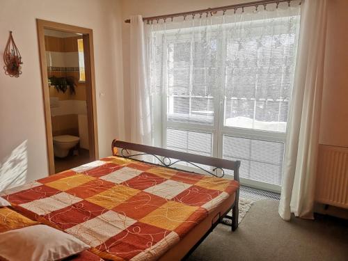 Ubytování Kuncovi في بيدريتشوف: غرفة نوم بسرير ونافذة كبيرة