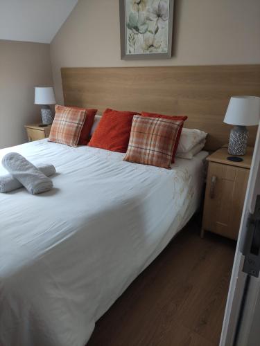 een groot wit bed met kussens erop bij Tollyrose Loft apartment in Newcastle
