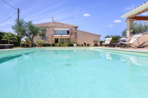 una gran piscina frente a una casa en L'Oustal d'Adèle proche Canal du Midi et Moissac, en Saint-Nicolas-de-la-Grave