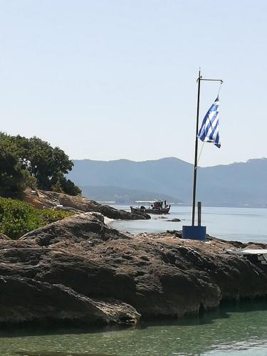 a flag on a rock in the water at Almira Kalamos in Kálamos