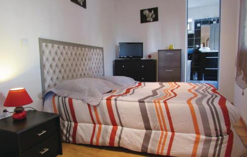 - une chambre avec un lit doté d'une couverture rayée et d'une lampe dans l'établissement 1 Bedroom Nice Apartment In Bastia, à Bastia