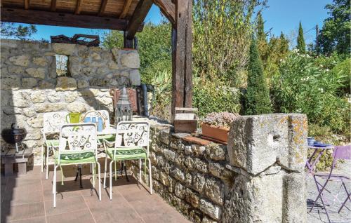 a patio with chairs and a table and a stone wall at 1 Bedroom Awesome Home In Sembas in Sembas