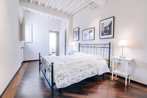 Uzzano的住宿－伊爾博爾戈德利阿布魯阿桂米度假屋，白色卧室配有黑色的床和一张桌子