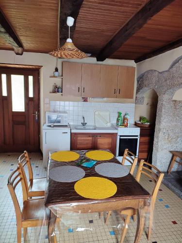 une cuisine avec une table et des chaises en bois et une cuisine avec une table dans l'établissement Maison spacieuse à Florentin-la-Capelle avec jardin 70 m², à Florentin-la-Capelle