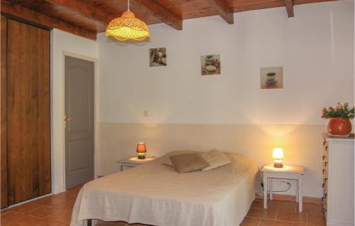 een slaapkamer met een bed en 2 tafels met lampen bij Beautiful Home In St, Julien De Peyrolas With Wifi in Aiguèze