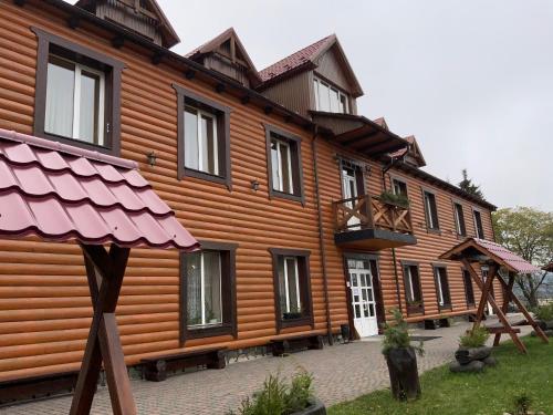 a large wooden house with black windows at Туристичний комплекс ВОРОХТА 365 Turistichesky Kompleks Vorokhta 365 in Vorokhta