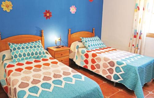two beds in a bedroom with blue walls at Lovely Home In Corumbela With House A Mountain View in Corumbela