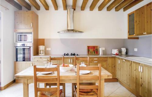 a kitchen with a wooden table and wooden cabinets at Nice Home In La Croupte With Wifi in La Croupte