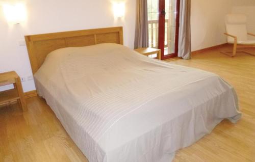 a white bed in a room with a wooden floor at Nice Home In La Croupte With Wifi in La Croupte