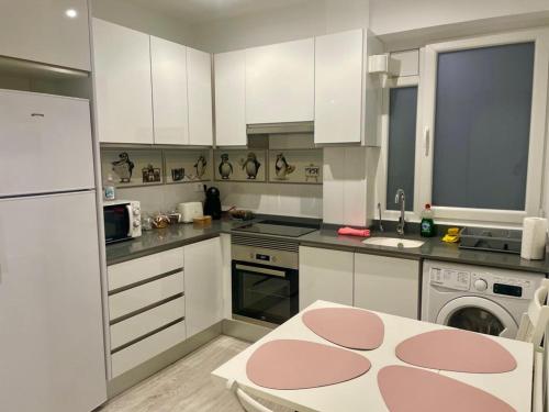 a kitchen with white cabinets and a pink rug on the floor at Bianca Home in Castellón de la Plana