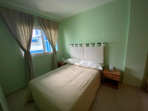 1 dormitorio con cama blanca y ventana en APARTAMENTO PUERTITO DE GUIMAR TEO, en Puertito de Güímar