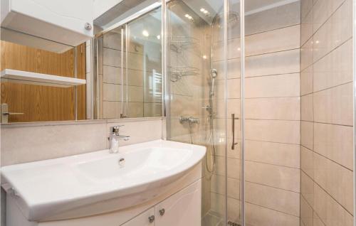 y baño blanco con lavabo y ducha. en Cozy Apartment In Lovran With Kitchen, en Lovran