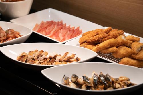 a table topped with bowls of different types of food at hotel H2 TRIP&BUSINESS NAGASAKI in Nagasaki
