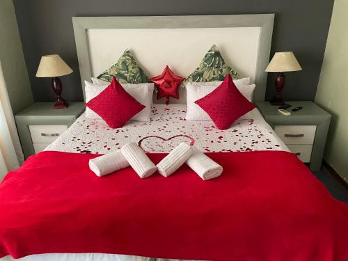 a bedroom with a red bed with red pillows at Marion Lodge in Johannesburg