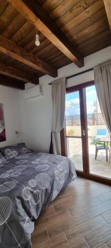 a bedroom with a bed and a view of a patio at Pambi House in Quartu SantʼElena