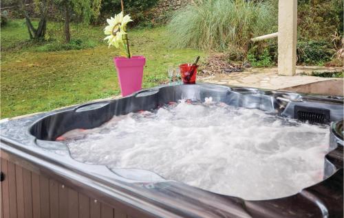 un bain à remous rempli d'eau dans un jardin dans l'établissement Nice Home In Salazac With Jacuzzi, à Salazac
