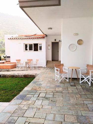 a patio with chairs and a table and a building at Idomeneas Apartments in Sougia
