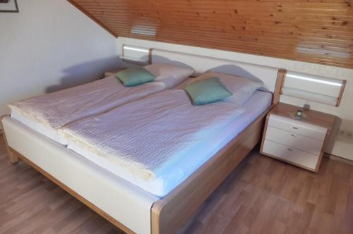1 dormitorio con 1 cama grande y cabecero de madera en Ferienwohnung Vogelsang, en Undeloh