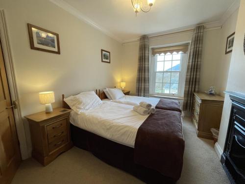a bedroom with a bed with a teddy bear on it at Tawny Cottage in Portinscale