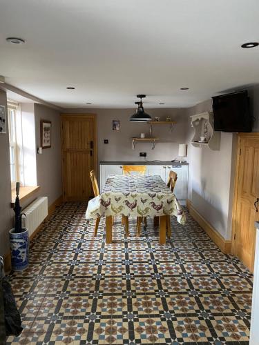 une salle à manger avec une table et des chaises sur un sol carrelé dans l'établissement Ivy House, three bed cottage, parking garden, à Skipsea