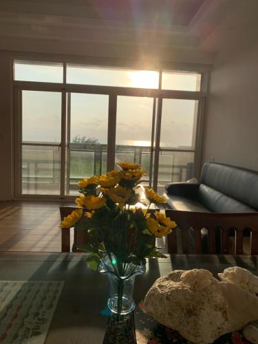 a vase of yellow flowers on a table in a living room at 三仙台心悅民宿 in Mei-sha-lu