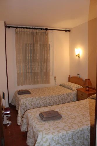 um quarto de hotel com três camas e uma janela em Club Nautic em Cambrils