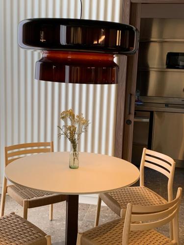 プッチェルダーにあるCIM HOTEL BOUTIQUEの花瓶付きのテーブルと椅子