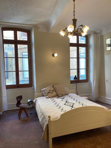 une chambre avec un lit et deux fenêtres dans l'établissement Maison d'Art, à Quillan
