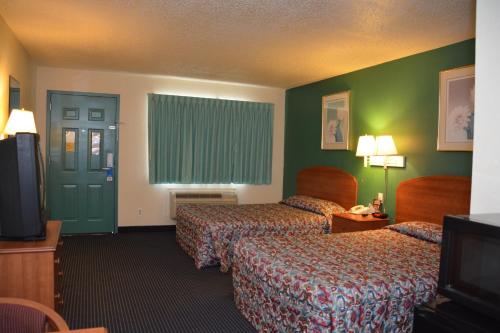 a hotel room with two beds and a television at Stay Express Inn Near Ft. Sam Houston in San Antonio