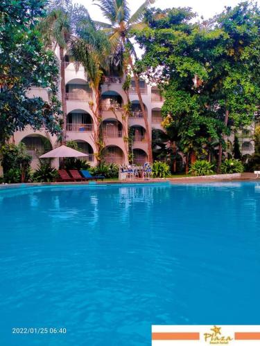 a large swimming pool in front of a building at Plaza Beach Hotel in Bamburi