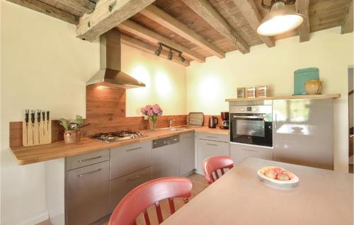 une cuisine avec une table et des chaises dans une pièce dans l'établissement 2 Bedroom Nice Home In Charritte De Bas, à Charritte-de-Bas