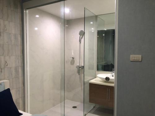 een glazen douche in een badkamer met een wastafel bij My Resort Hua Hin A206 in Hua Hin