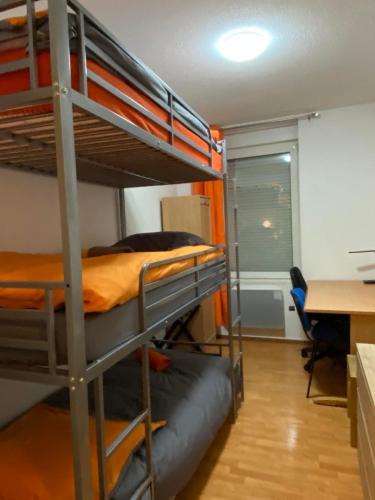 une chambre avec trois lits superposés et un bureau dans l'établissement Grand'Roche, à Cornimont