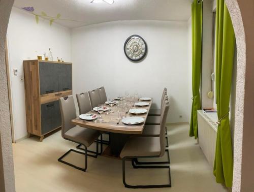 une table à manger avec des chaises et une horloge murale dans l'établissement Grand'Roche, à Cornimont