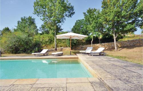- une piscine avec 2 chaises longues et un parasol dans l'établissement Cozy Home In Carnac-Rouffiac, à Carnac-Rouffiac